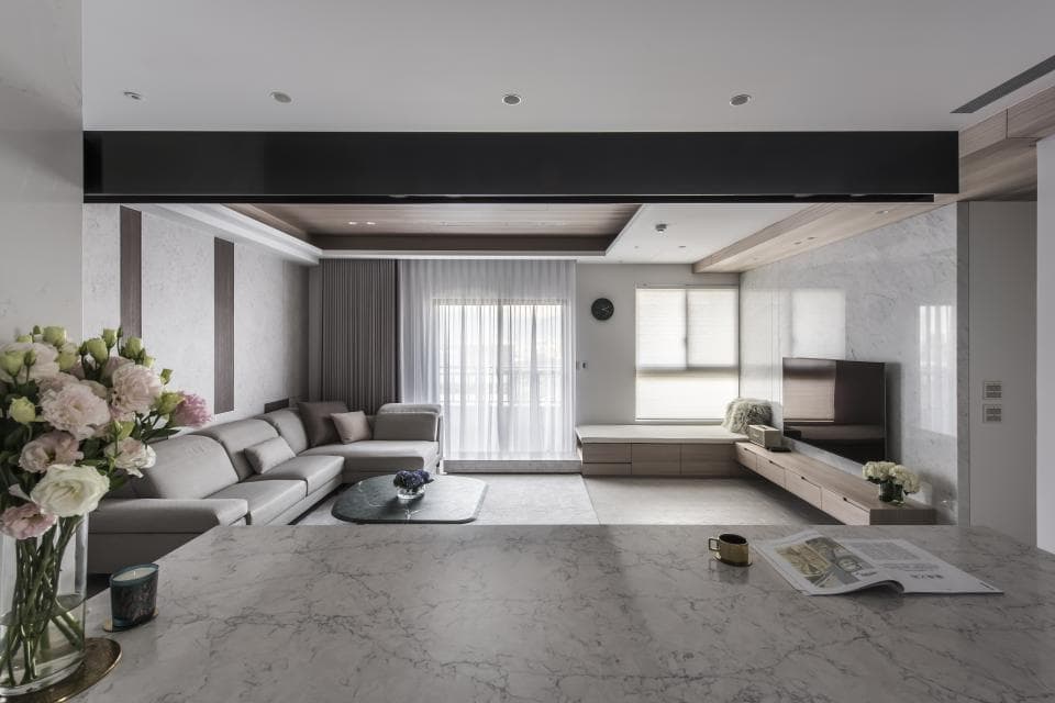 這張「現代客廳」的照片是一個開放式空間,有沙發、電視和一個大窗戶。房間以白色和灰色為主色調,給人一種簡約舒適的感覺。