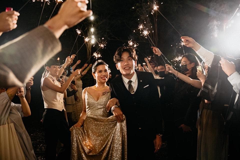 這張「婚禮」的照片是新郎新娘在夜晚的戶外與賓客們一起手持煙火棒,慶祝他們的婚禮。