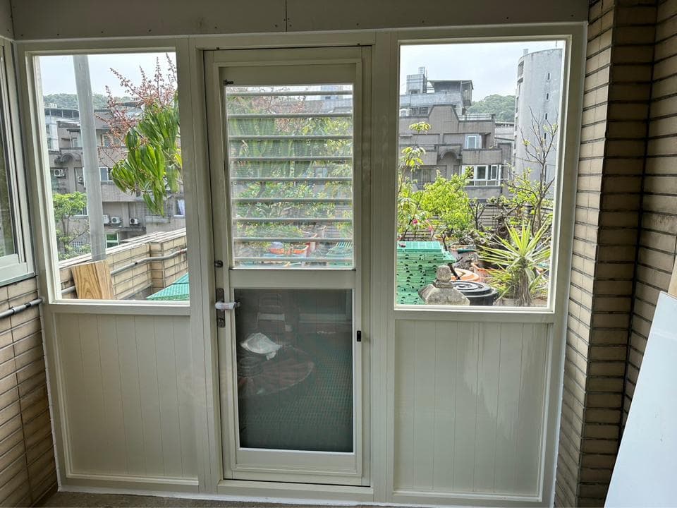 這是一張照片,顯示一扇玻璃窗和門,位於一棟建築物的陽台