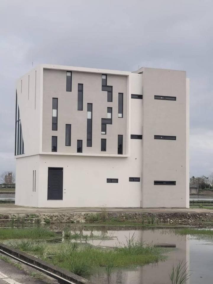 1) 照片顯示一個現代的建築物,建築物有水泥牆壁和大量的黑色窗戶