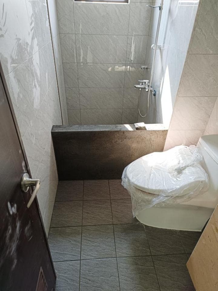 1) 照片顯示一個浴室,浴室裡有馬桶、淋浴、浴缸和瓷磚地板