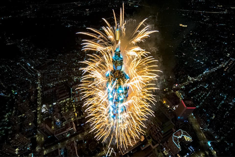 這張照片是一座高聳的建築物,周圍環繞著耀眼的煙火,襯托出節慶的熱鬧氣氛。