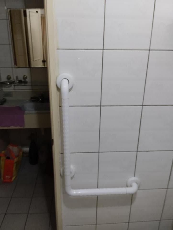 1) 照片顯示一個白色的浴室扶手安裝在瓷磚牆上,扶手有兩個彎曲,一個在上方,另一個在下方