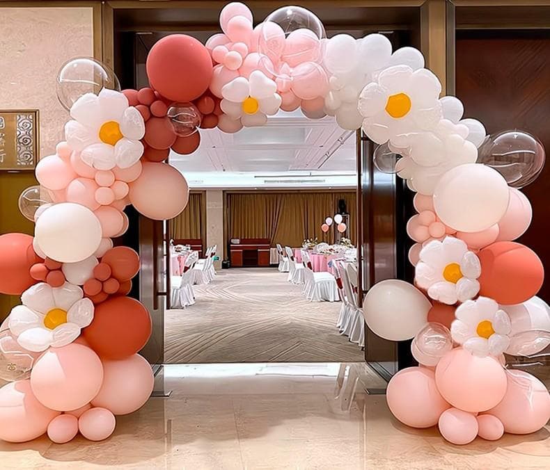 1) 照片中展示了一個用粉色、白色和珊瑚色氣球製作的拱門,氣球上裝飾著花朵