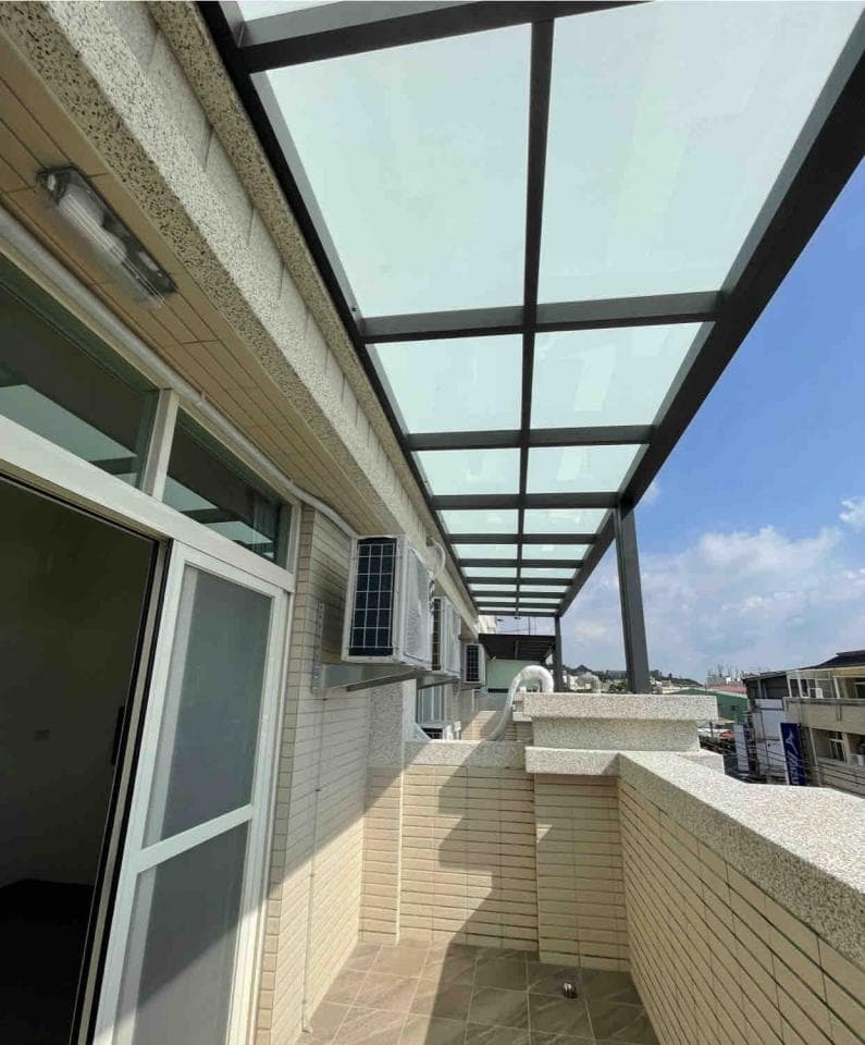 這張「陽臺」的照片是,有一個玻璃屋頂,牆壁是磚頭做的,陽臺有兩個空調。