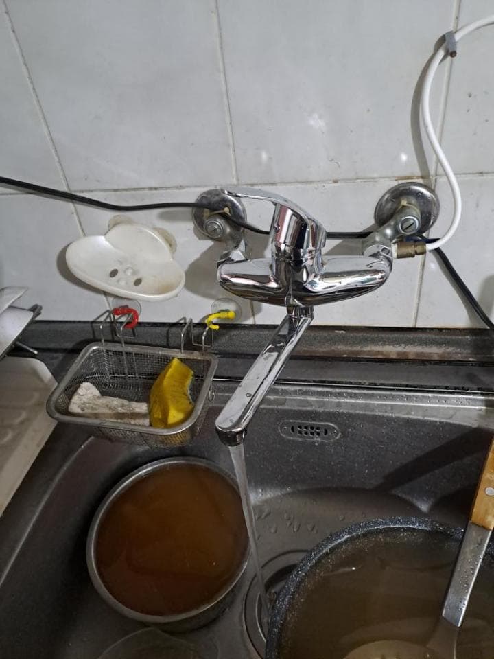 這張照片是廚房水槽裡的水龍頭正在滴水,看起來需要修理。