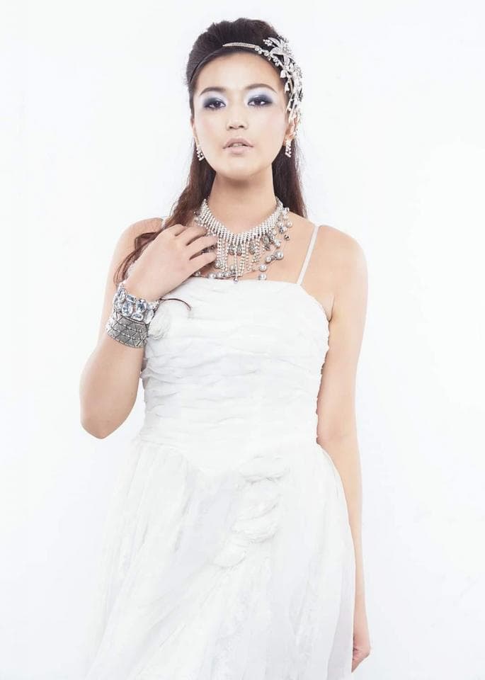 這張「婚紗照」的照片是一位穿著白色婚紗的女性,她戴著閃亮的頭飾和項鍊,看起來很漂亮。