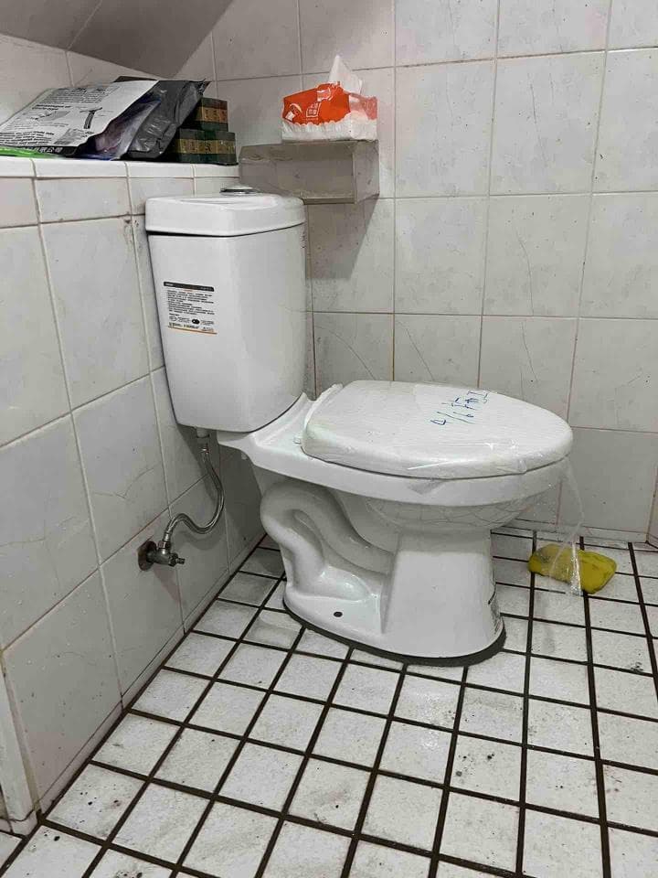 這張照片是一個浴室,照片中最重要的部分是馬桶。馬桶是白色的,看起來很新,旁邊有一個紙巾盒。