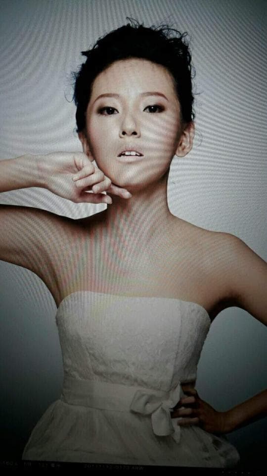 這張「一位年輕女子穿著白色禮服,面帶微笑」的照片是。