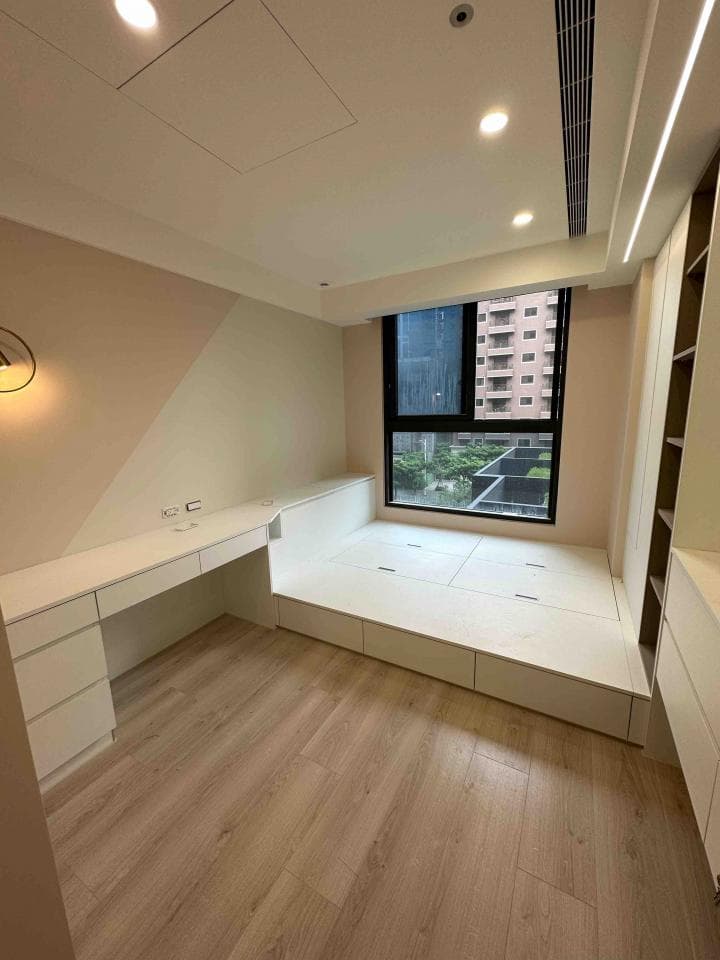 1) 照片顯示一個裝潢精緻的臥室,房間角落有白色木質的平台床,床邊設置了白色木質的書桌,牆壁刷上米白色,採光良好,室內設計簡潔明亮