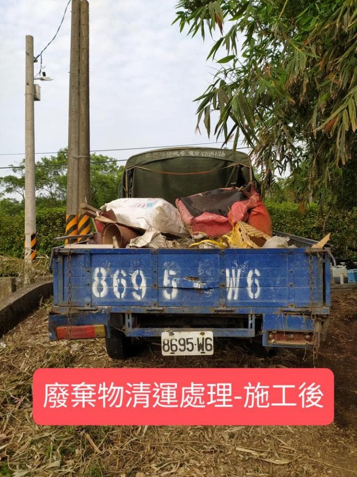 1) 照片顯示一輛卡車,車斗裝滿了廢棄物,車身印有「8695-W6」的字樣,卡車停放在道路旁,道路旁覆蓋著落葉