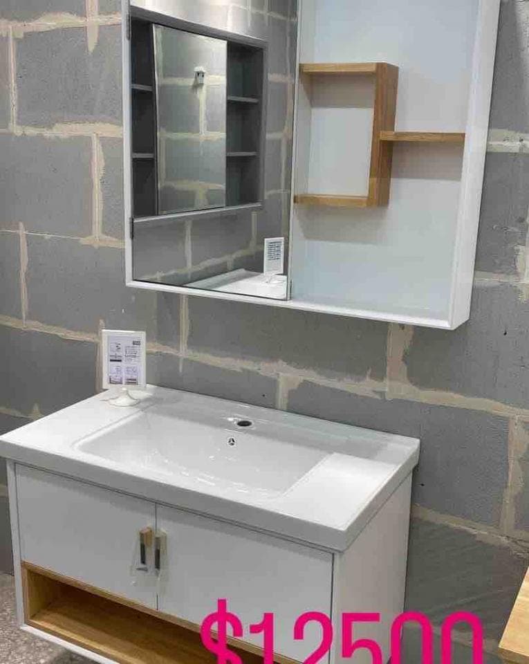 這張照片是浴室的洗手台,它有一個白色陶瓷的洗手盆和一個下方帶有兩個抽屜的白色櫃子,櫃子下方有一個木架,上面寫着$1250。