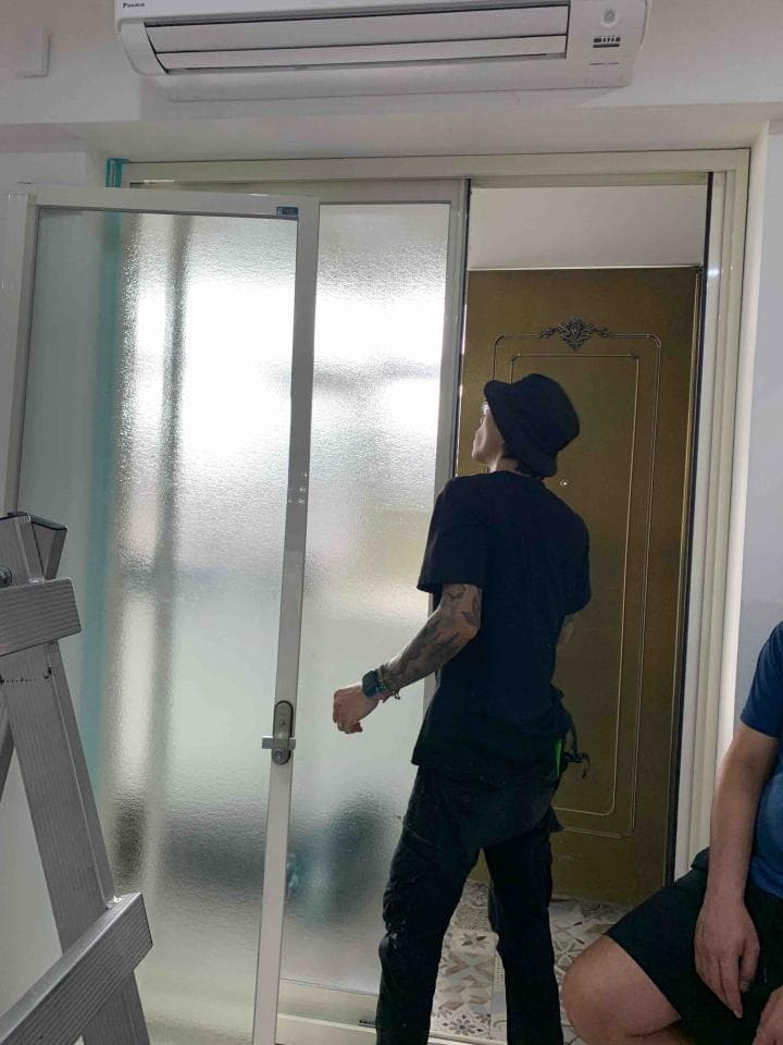 這張照片是一個男人正在開門,門的玻璃是霧面的,讓室內看起來更模糊。