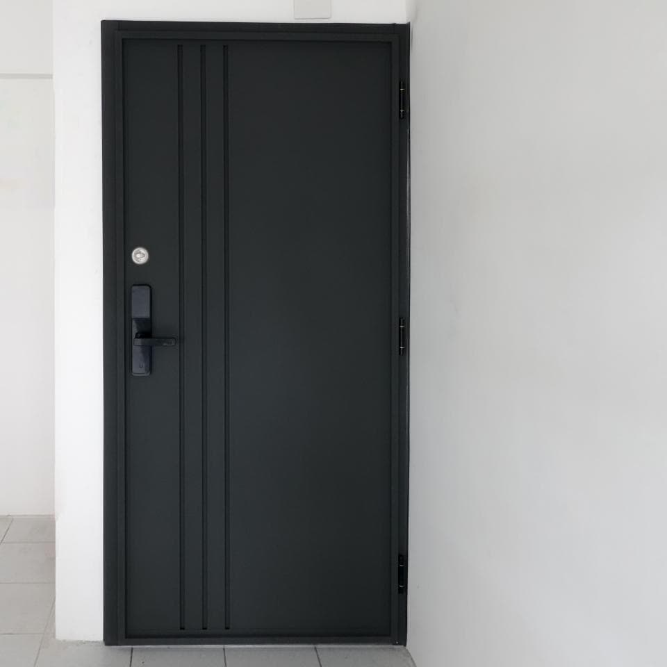 這張照片是一扇黑色的鋼門,門上有三條垂直的線條,門把是黑色的,門鎖是銀色的。