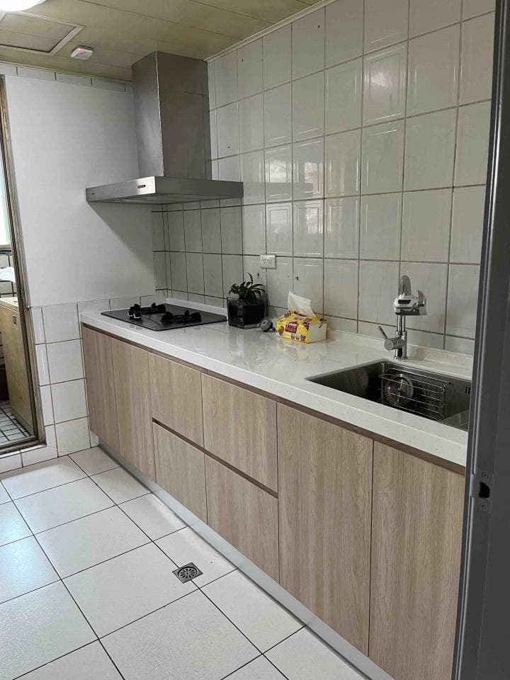 這張照片是一間廚房,最重要的是木紋櫥櫃,它佔據了照片的大部分空間,看起來很新,顏色很溫暖。