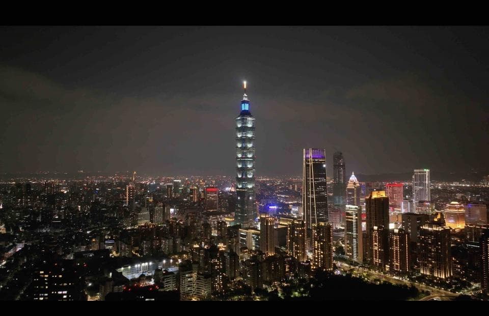 這張照片是一座高聳入雲的摩天大樓,佇立在繁華的都市中,在夜色的襯托下顯得格外耀眼。周圍的高樓大廈在燈光的映照下,宛如繁星點點,構成一幅美麗的夜景。