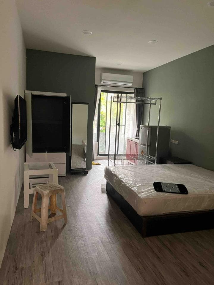 1) 照片顯示一個簡約的房間,房間裡有一張床,一個衣櫃,一個書桌,一張椅子,還有電視