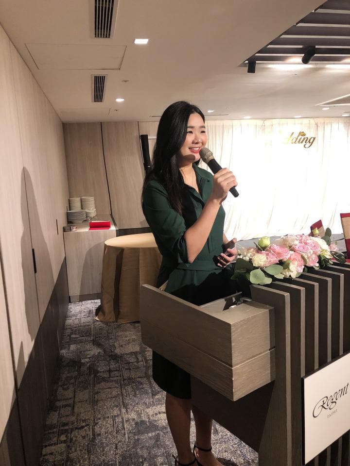 這張「婚禮」的照片是一名女性在臺上拿著麥克風講話。