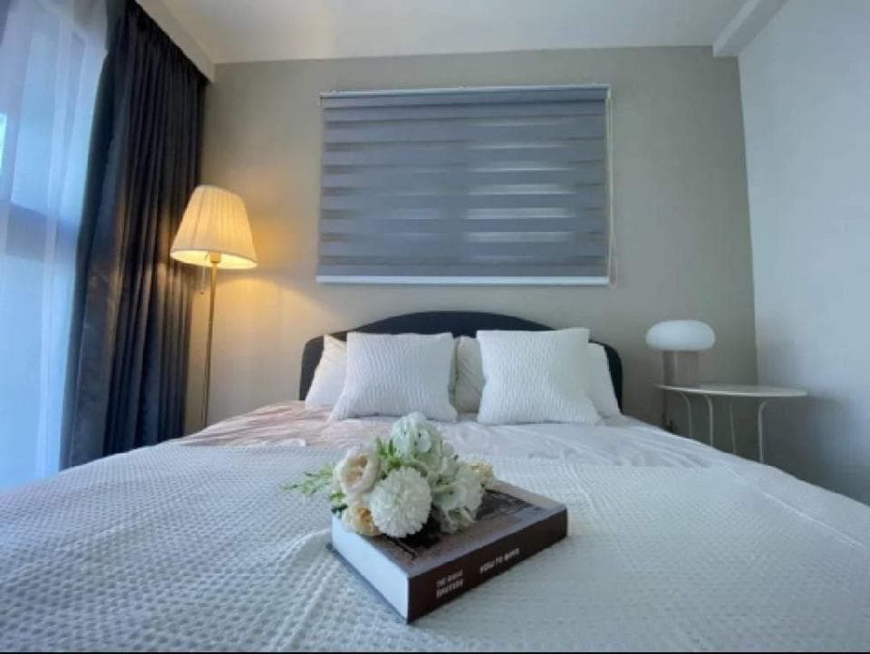 1) 一張白色床單的床,上面放著一束花和一本書