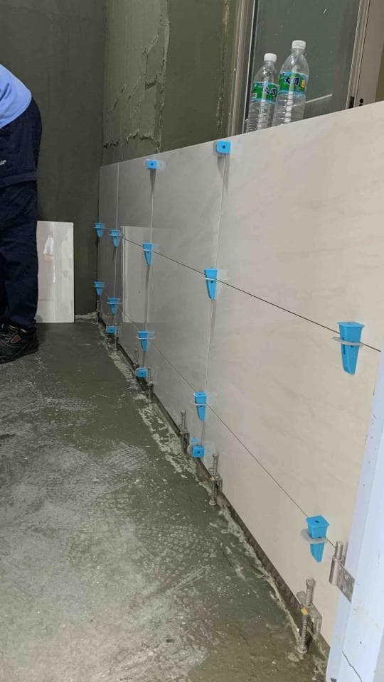 1) 照片顯示一個正在鋪設瓷磚的浴室