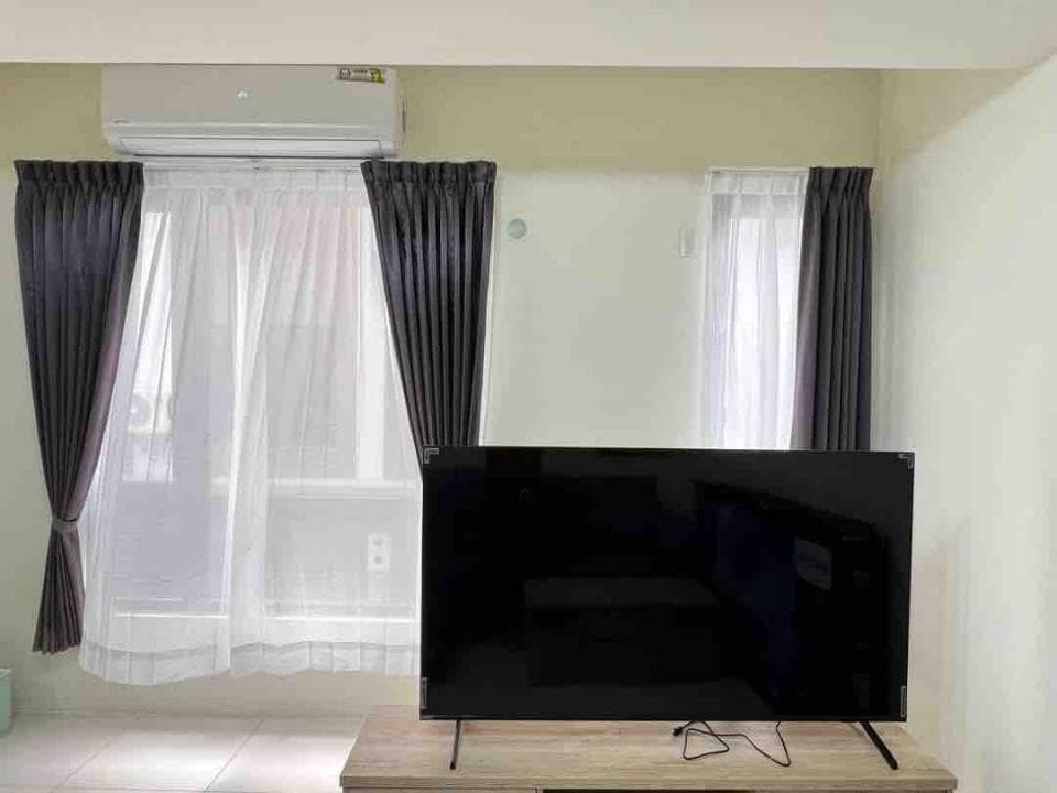 1) 照片顯示一間客廳,裡頭有電視、窗簾和冷氣機