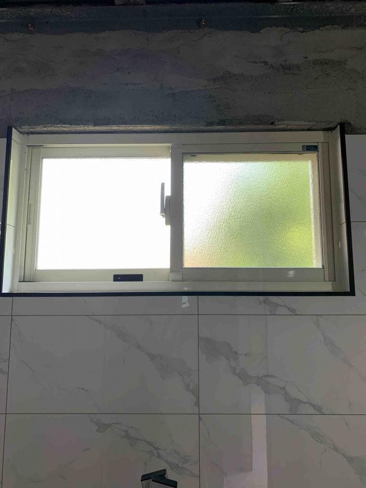 1) 這是一張浴室的照片,照片中有一個白色瓷磚牆壁和一個窗戶