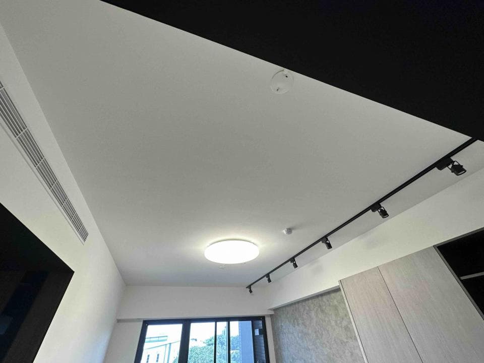 1) 這是一張室內天花板的照片,天花板是白色,有黑色軌道燈,天花板中央有一盞圓形燈