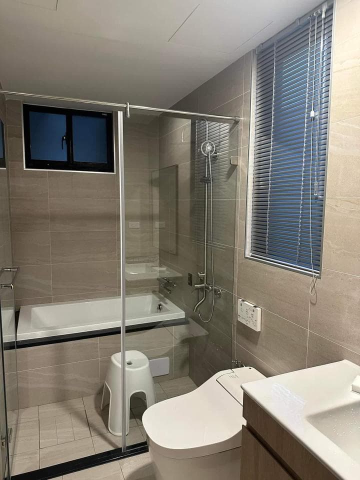 1) 照片顯示一個浴室,裡面有一個浴缸、馬桶、洗手台、淋浴間、一個小凳子、一個窗戶和一個鏡子