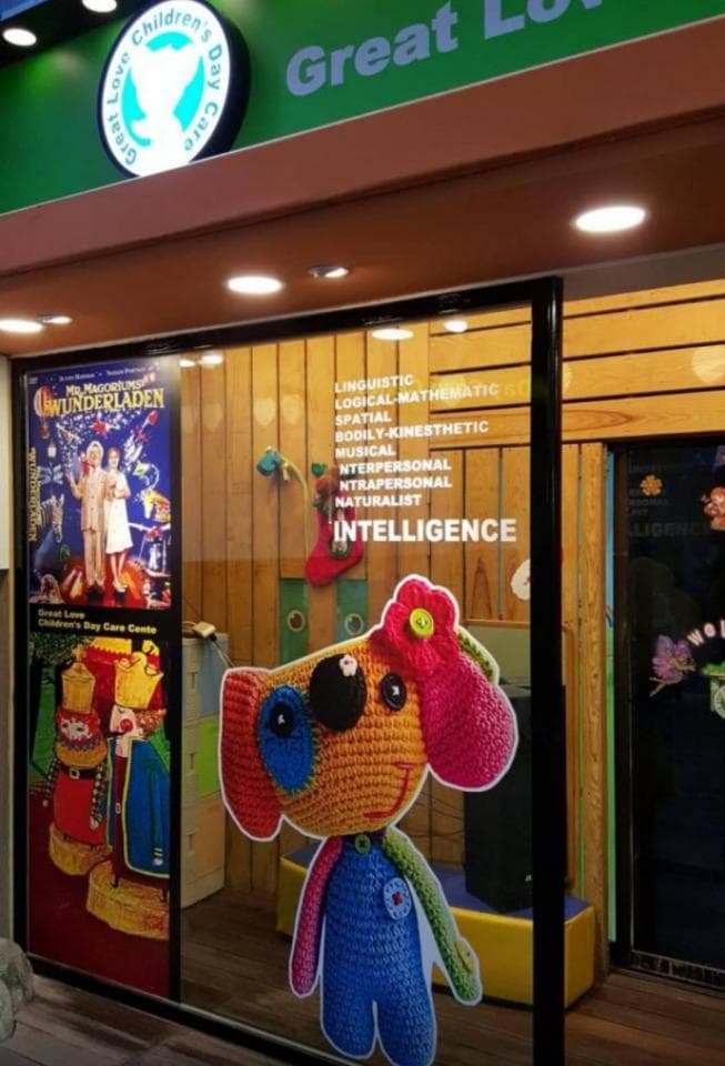 這張「商店」的照片是一個兒童遊樂中心,櫥窗上有一個毛絨玩具狗,旁邊貼著一個寫著「INTELLIGENCE」的標語。