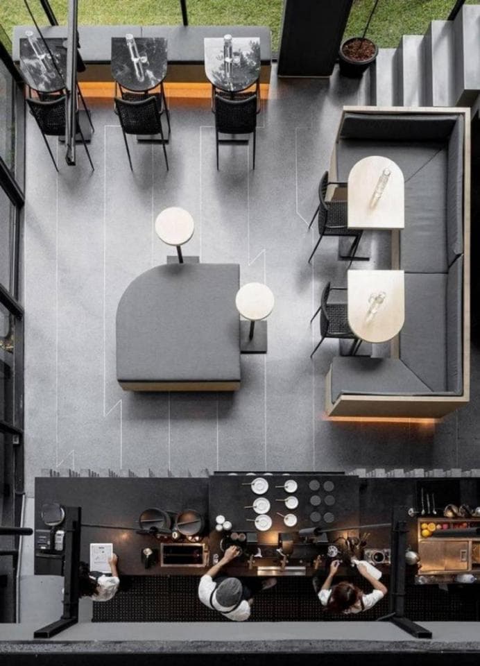 這張「咖啡廳」的照片是一個時尚的咖啡廳,有吧檯、座位區和幾個桌子。照片從上往下拍攝,展示了整個咖啡廳的佈局。