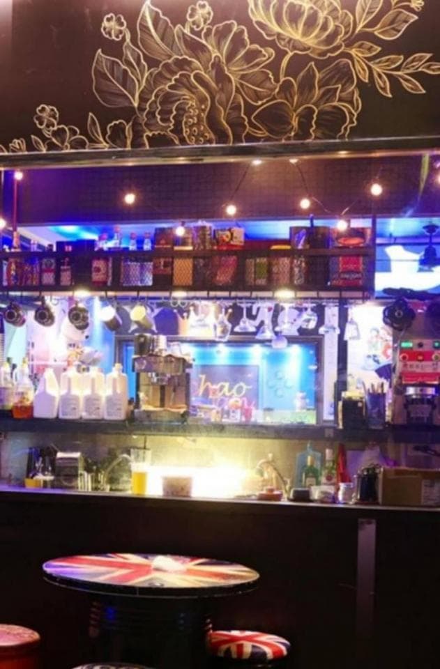 這張酒吧的照片是一個有吧檯、酒瓶和桌子的酒吧。