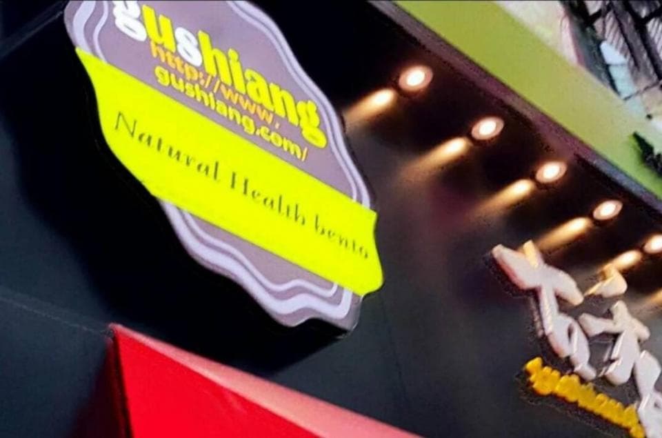 這張「招牌」的照片是一個中餐廳,上面寫著「Natural Health Bento」 和「Gushiang」以及餐廳的網站地址。