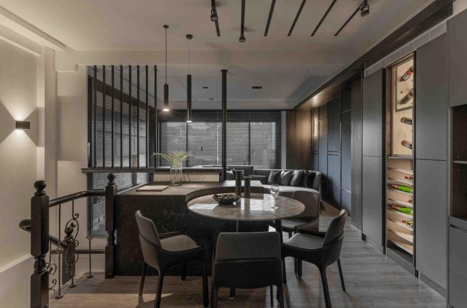 這張「現代風格住宅」的照片是,一個開放式廚房和用餐區,設有黑色餐桌和椅子,以及一個大型酒櫃。