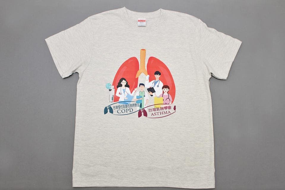 這張照片是一件印有圖案的淺灰色T恤。圖案是兩個肺,周圍有醫生和病人,下方寫著「慢性阻塞性肺病 COPD」和「氣喘 ASTHMA」。