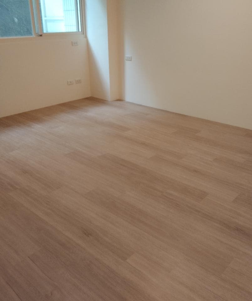 1) 照片顯示一個空房間,牆壁是白色的,地板是木質地板