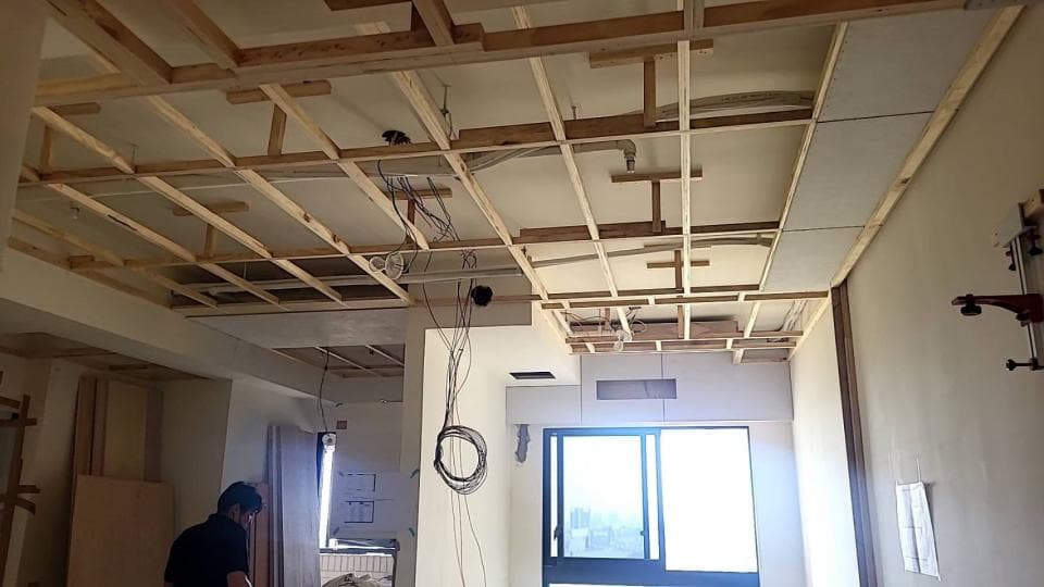 這張照片是一間正在裝修的房間,最重要的是房間的天花板正在施工,可以看到許多木條組成的框架,這些木條是用來支撐天花板的,讓天花板更加堅固。