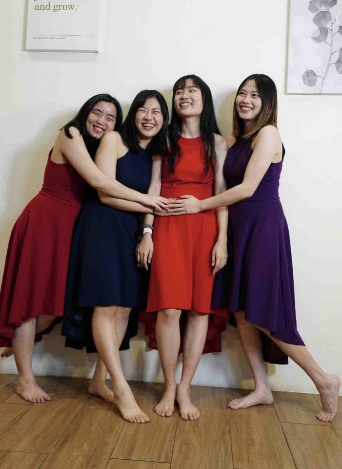 這張照片是四個年輕女性穿著不同顏色的洋裝站在一起,她們看起來很開心,友誼是這張照片中最重要的地方。