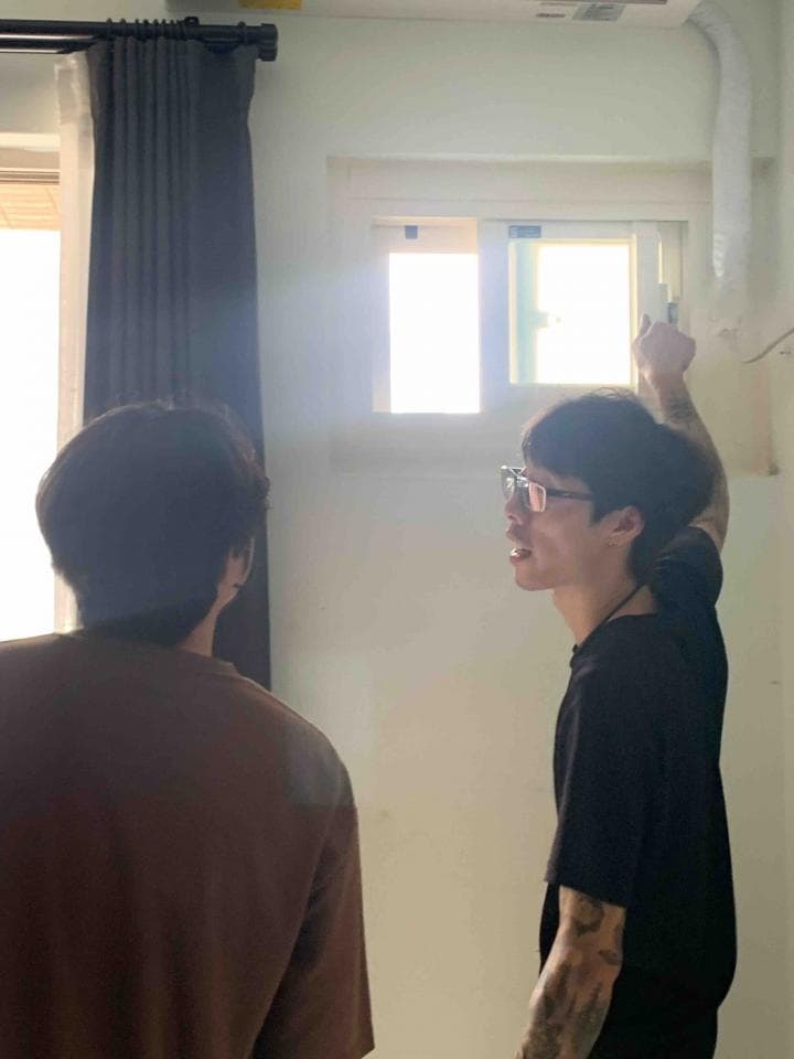 1. 照片中顯示兩個人站在房間裡,其中一人背對鏡頭,另一人則面朝鏡頭