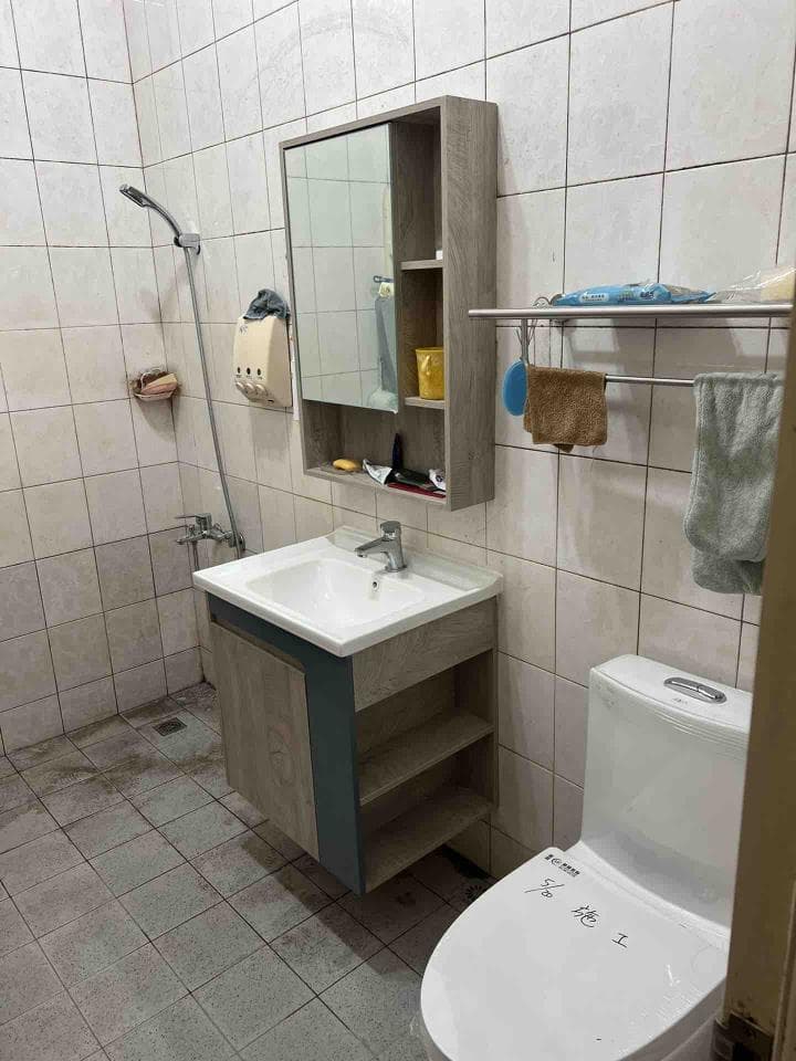 1. 照片顯示一個浴室的洗手台和馬桶,洗手台上有個鏡子櫃,櫃子裡放了一些用品