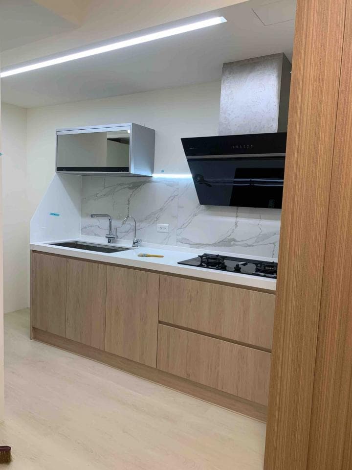 這張照片是一個現代化廚房,最重要的是木紋的櫥櫃,給人一種簡潔、時尚的視覺感受。