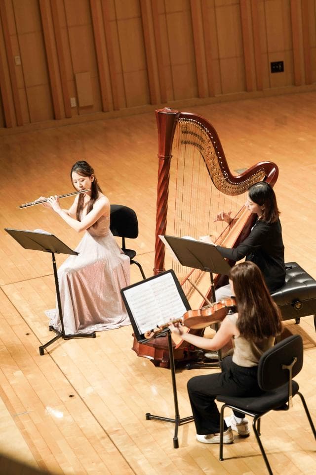 1) 照片中,三位女性演奏者正在演奏音樂