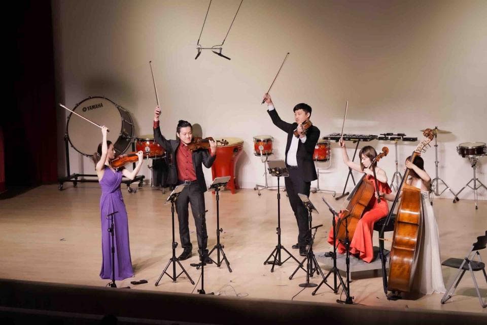1) 這張照片顯示四位音樂家正在舞台上演奏