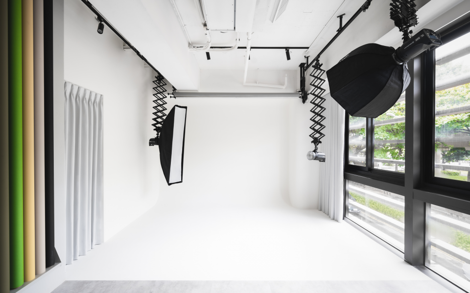 這張照片是一個攝影棚,其中最重要的是兩個吊在棚頂的攝影燈。燈光設備可以讓攝影師在拍攝時有充足的光線。