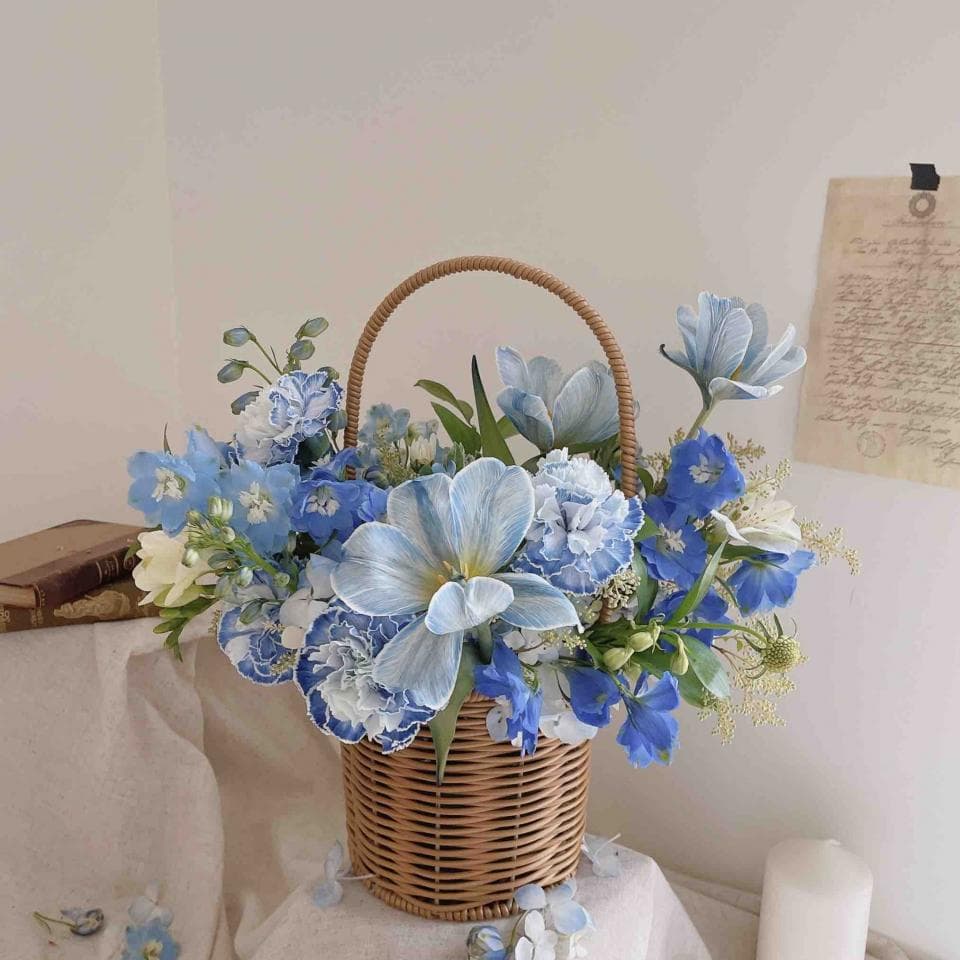 1) 照片顯示一個裝滿藍色和白色花朵的柳條籃子