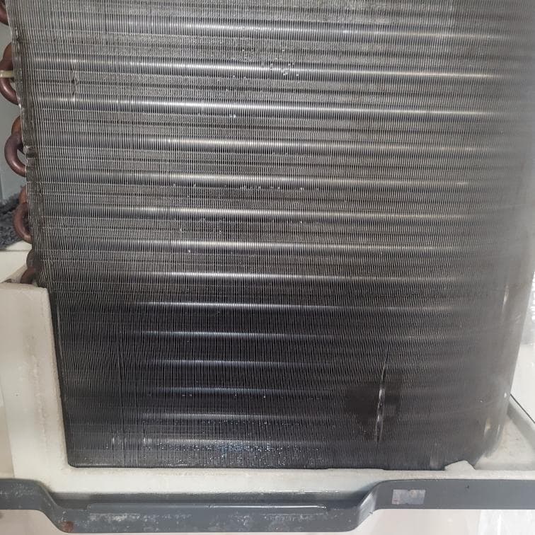 1. 這張照片顯示了一個髒的空調室外機,上面覆蓋著灰塵和碎屑