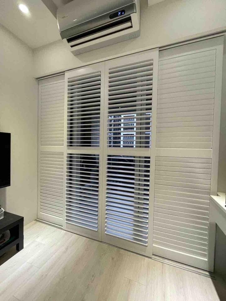 1) 照片顯示一個房間,房間裡有一個白色百葉窗,牆壁是白色的,房間地板是淺木紋地板