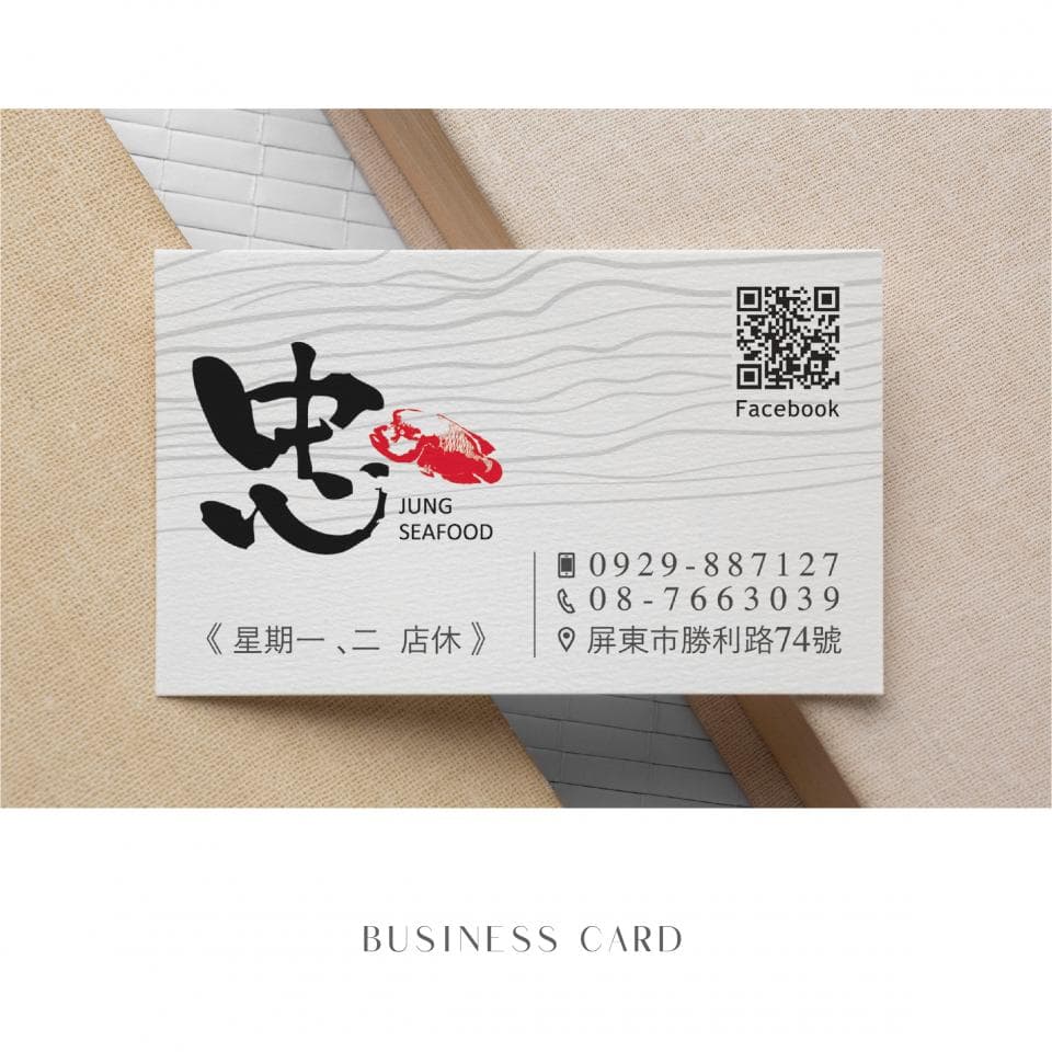 這張照片是一張名片,最重要的是名片的左上角,上面印有「忠」字,字體很大,旁邊配有紅色龍蝦圖案,下面寫著「JUNG SEAFOOD」,是這家海鮮店的招牌。
