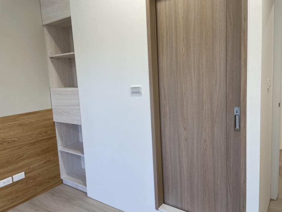 這張照片是一道木紋滑門,門板上有木紋紋理,看起來很自然,門把手是銀色的,整體設計簡潔大方。