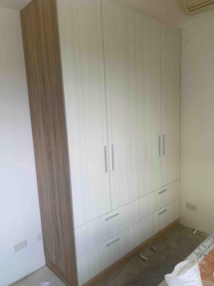 這張照片是一個白色木頭製成的衣櫃,有四扇門和三層抽屜。