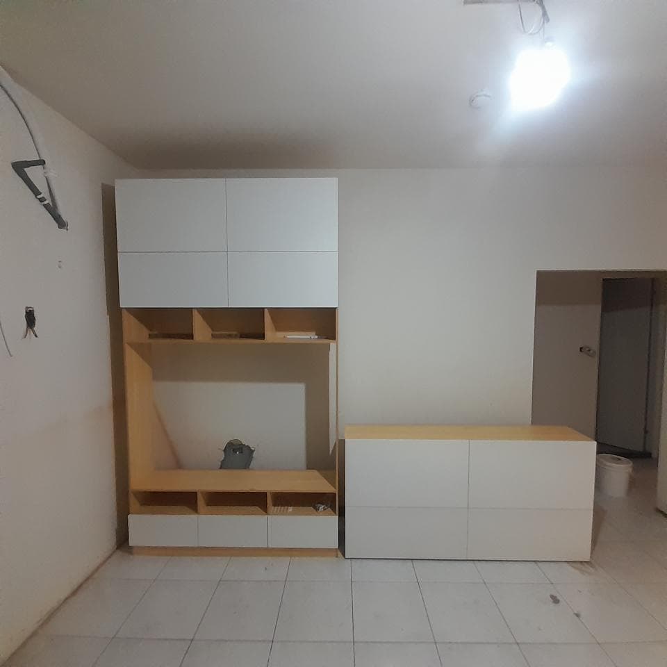 1) 照片顯示一個房間,牆壁上有一個白色的木櫃,櫃子下面有一個木質的平台,房間裡還有一個白色的木櫃